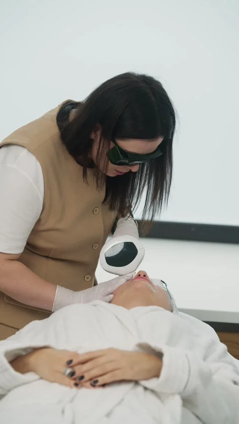 Cosmetologist performs a hardware procedure to remove blood vessels and pigment Stock Footage 307070767