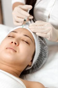 The cosmetologist performs the injection Stockfoto's