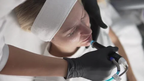 A cosmetologist performs a procedure on the Hydrafacial device, Stock Footage 286701998