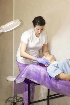 The cosmetologist prepares the client for the procedures Stock Photos