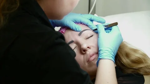 Cosmetologist preparing eyebrows for the permanent makeup Stock Footage 74212202
