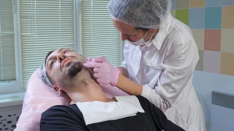 Cosmetologist puts an injection to a man Stock Footage 105275641