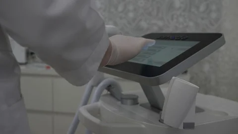 Cosmetologist selects settings for laser epilation treatment on device screen 스톡 동영상 90601767