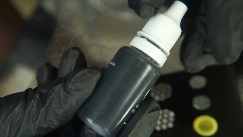 A cosmetologist, a specialist in permanent make-up, opens a jar of paint before Stock Footage 83340392