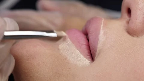 A cosmetologist uses a brush to create the contour of a woman's lips. Stock Footage 278222592