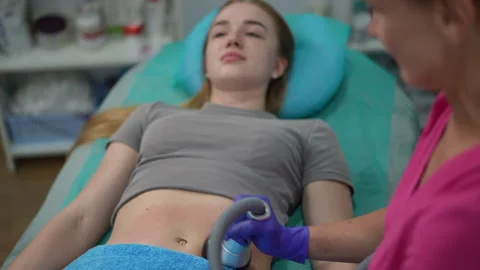 Cosmetologist using vacuum device on woman’s abdomen during body procedure Stock Footage 311364485