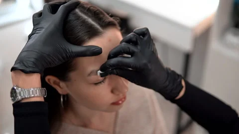 Cosmetologist's hands wiping eyebrows using cotton pads Stockbeeldmateriaal 146530528