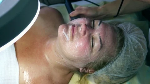 Cosmetology, cosmetic and SPA. Middle-aged woman on treatment by a cosmetologist Stock Footage