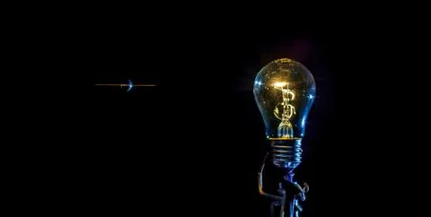 Cosmic explosion of a burning light bulb with flying splinters and smoke on a Stock Photos