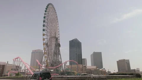 Cosmo Clock 21 Ferris Wheel And Vanish Diving Coaster Pink Track With Cityscape Stock Footage 344092566