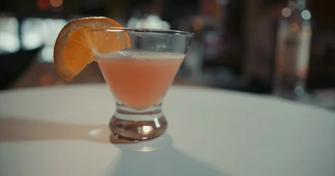 Cosmopolitan martini with an orange slice on a bar Video stock 105298428