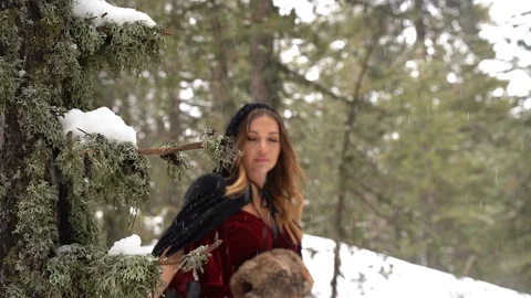 Cosplay model looking from behind the a in a winter forest Stock Footage 125799610