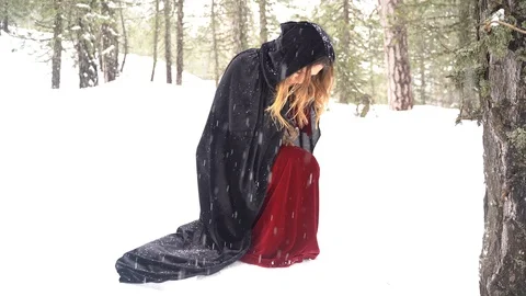 Cosplay model standing up from a knees in a winter forest Stock Footage 125796882