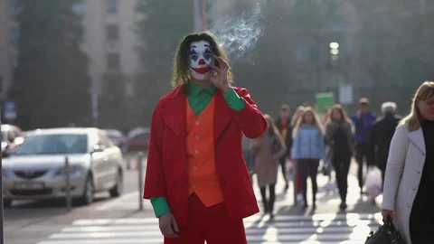 Cosplayer portrays clown Arthur Fleck from thriller "Joker" at city street. Stock Footage 123428657
