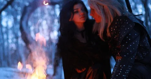 Cosplayers in image of ancient warrior and witch embrace next to bonfire. Stock Footage 124728003