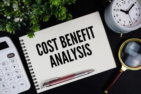 Cost Benefit Analysis text written on notepad with alarm clock, magnifying .. Stock Photos