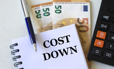 COST DOWN word in a notebook against the background of calculitar and banknot Stock Photos