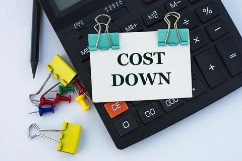 COST DOWN - words on a white sheet with clips on a white background with a ca Stock Photos