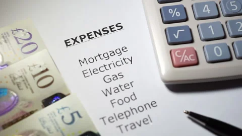 A cost of living list of expenses. With calculator and cash note money. Stock Footage