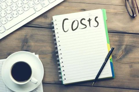 Costs text on notebook on working table Stock Photos