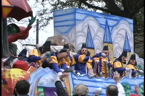 Costumed figures on a float throw out strands of different colored beads to Video stock 438460