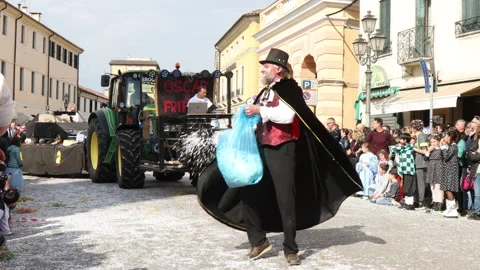 Costumed man throwing confetti during a street carnival in Piove di Sacco, Italy Stock Footage 239026057