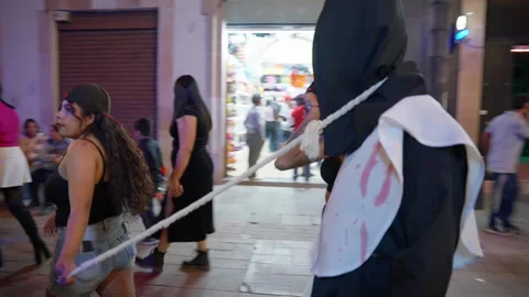 Costumed people walking through crowded street during Day of the Dead parade. Video stock 337906192