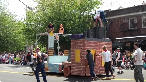 Costumed performers on a brick and construction themed parade float Stock Footage 339036411