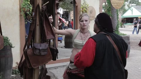 Costumed Performers Talking by a Leather Craft Stall at Renaissance Faire Stock Footage 345275797