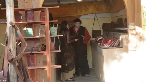 Costumed Vendors Talking at Renaissance Fair Leather Goods Stall Stock Footage 345275404