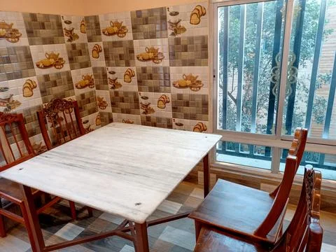 Cosy dining Space with a marble dining table, wooden chairs and decorative Stock Photos