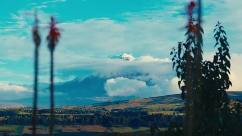 Cotopaxi volcano emerges from clouds above a lush valley in Ecuador Stock Footage 345158305