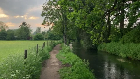 Cotswolds river flowing besides footpath as the sunsets Stock Footage 275667083