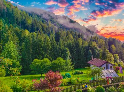 Cottage at the base of the mountain in the meadow Stock Photos