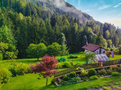 Cottage at the base of the mountain in the meadow Stock Photos