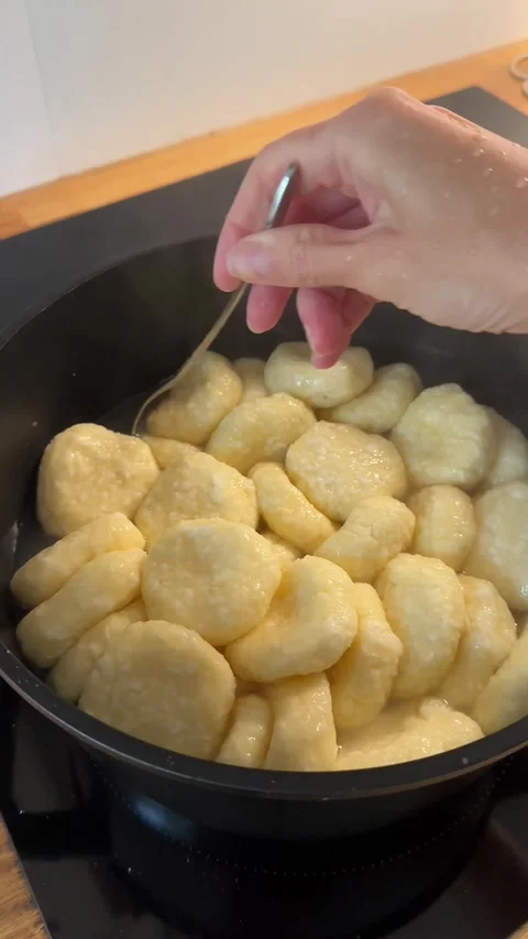 Cottage Cheese Dumplings Boiling in Pot and Stirred with Spoon Stock Footage 344602224
