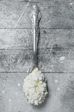 Cottage cheese on a spoon. Stock Photos