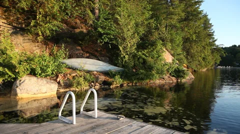 COTTAGE: Serene Dock Setting with Canoe Stock Footage 39785138