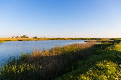 Cottage surrounded by stubble fields by the river in Evros Delta, Greece Foto stock