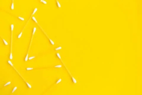 Cotton buds pattern on yellow background, top view, copy space Stock Photos