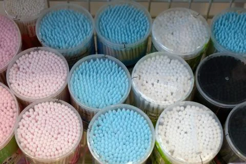 Cotton buds in plastic cylindrical boxes with lids, boxes of different sizes. Stock Photos