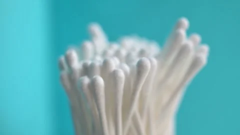 Cotton Swabs on Turquoise Background: Soft Focus Close-Up for Personal Care Stock Footage 327957375