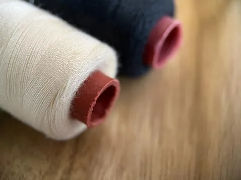 Cotton thread on spool for sewing material with wood background Stock Photos