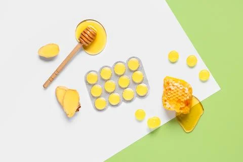 Cough drops in blister with ginger root slices, honeycomb and dipper on color Stock Photos