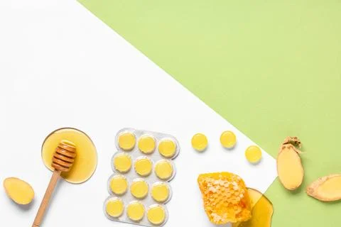 Cough drops in blister with ginger root slices, honeycomb and dipper on color Stock Photos