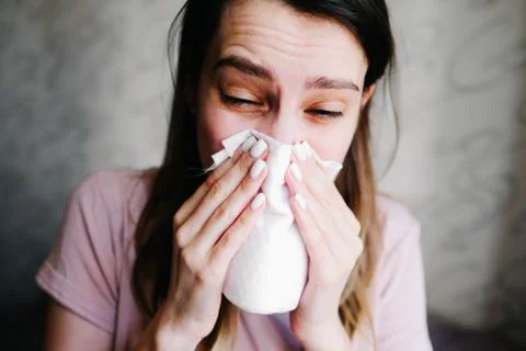 Cough in tissue covering nose and mouth when coughing as COVID-19 Stock Photos