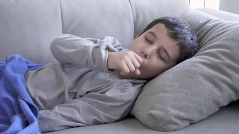 Coughing into fist while lying on couch Vidéo 316749338