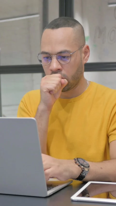 Coughing Hispanic Man Using Laptop in Office, vertical video Stock Footage 325703539