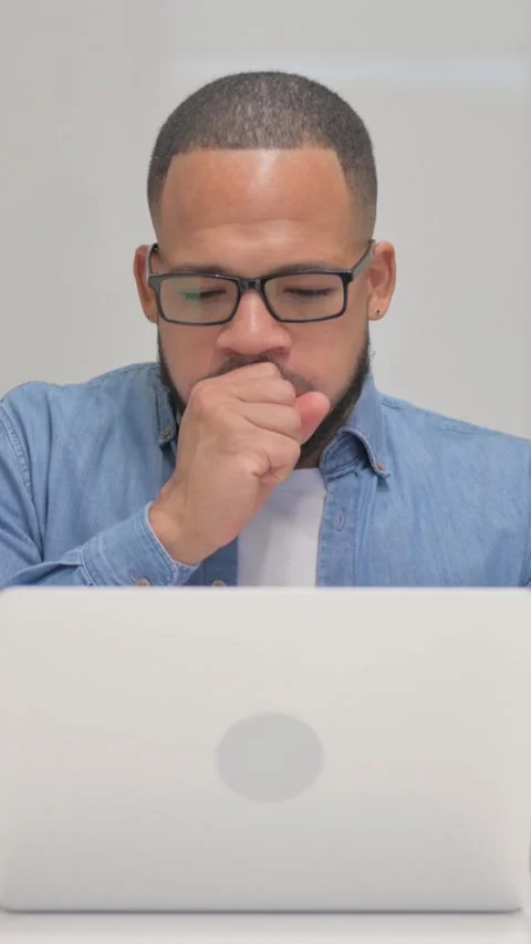 Coughing Mixed Race Man Using Laptop, vertical video Video stock 325712455