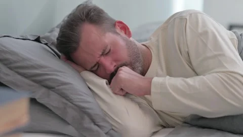 Coughing Sick Middle Aged Man Lying on Side in Bed Stock Footage 287899287